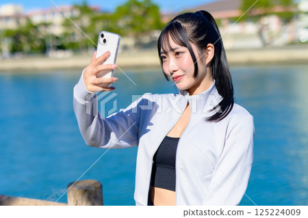 Cute woman taking a selfie with her smartphone in hand Selfie SNS Daily life Photogenic Cropped up Cute woman taking a selfie with her smartphone in hand Selfie SNS Daily life Photogenic Cropped up 125224009