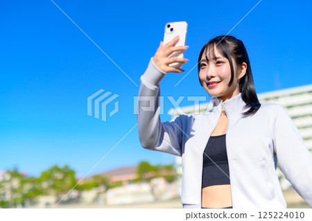 Cute woman taking a selfie with her smartphone in hand Selfie SNS Daily Life Photogenic 125224010
