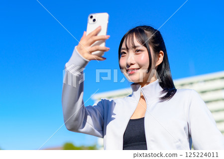 Cute woman taking a selfie with her smartphone in hand Selfie SNS Daily life Photogenic Cropped up Cute woman taking a selfie with her smartphone in hand Selfie SNS Daily life Photogenic Cropped up 125224011