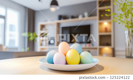 Colourful painted Easter eggs and a vase with green flowers stand on a wooden table in a modern kitchen. Easter decor for cozy home. Empty space. This is AI-generated item 125224122