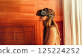 Young Woman Engaged in Virtual Reality With Headset in Modern Setting 125224252