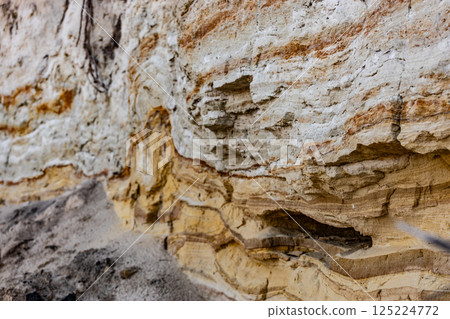A Close-Up View of Multi-Colored Sandstone Layers Exposed on a Cliffside, Showcasing Natural Erosion Patterns and Geological Strata 125224772