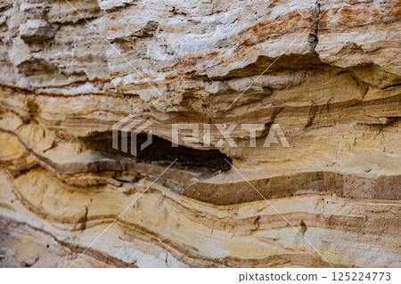 Intricate Layered Rock Formation: A Stunning Display of Natural Geological Patterns and Textures Revealed in this Close-Up Photograph of Sedimentary Layers and Their Colors 125224773