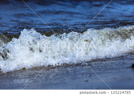 Capturing the Essence of Ocean Waves: A Crystal Clear View of Refreshing Coastal Waters in Motion and Their Textures Shining in the Natural Light of Day on the Shoreline 125224785