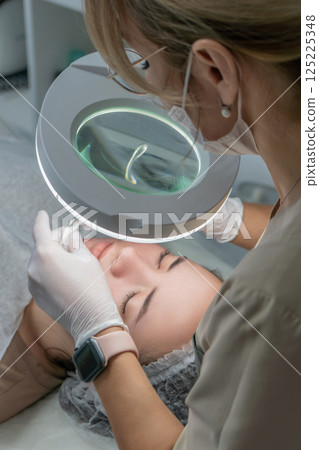 Microneedling Treatment Clinic Facial Aesthetics: Professional performs microneedling procedure on client's face. Microneedling Treatment Clinic Facial Aesthetics: Professional performs microneedling procedure on client's face. 125225348