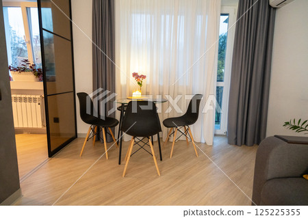 Apartment Dining Room Glass Table Modern Interior Design: Cozy apartment's glass table, four chairs, stylish interior, daytime. Apartment Dining Room Glass Table Modern Interior Design: Cozy apartment's glass table, four chairs, stylish interior, daytime. 125225355