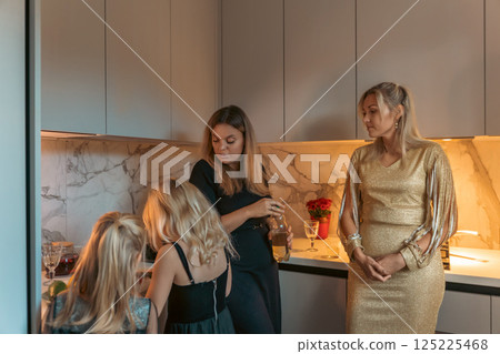 Women, Kitchen, Gathering: Modern apartment, evening, family celebration. Women, Kitchen, Gathering: Modern apartment, evening, family celebration. 125225468