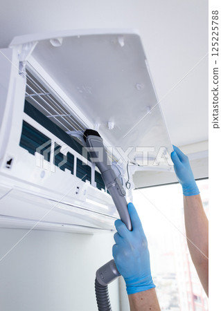 Efficient Air Conditioner Maintenance: Cleaning the Filter with Care for Optimal Performance and Longevity 125225788