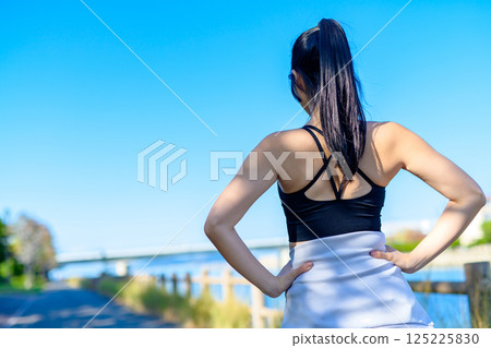 Back view of a cool woman exercising under the blue sky Walking Diet Exercise Exercise 125225830