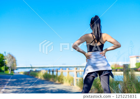Back view of a cool woman exercising under the blue sky Walking Diet Exercise Exercise Back view of a cool woman exercising under the blue sky Walking Diet Exercise Exercise 125225831