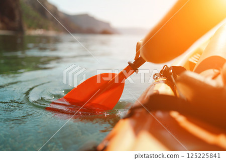 Kayak paddle sea vacation. Person paddles with orange paddle oar on kayak in sea. Leisure active lifestyle recreation activity rest tourism travel 125225841