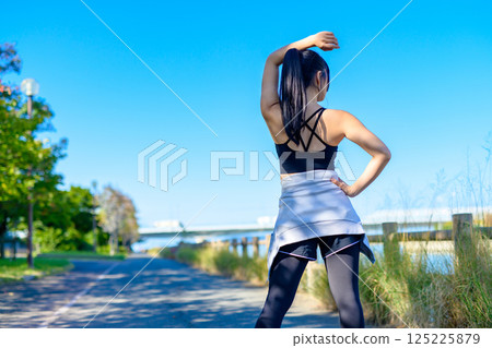 Back view of a cool woman exercising under the blue sky Walking Diet Exercise Exercise Back view of a cool woman exercising under the blue sky Walking Diet Exercise Exercise 125225879