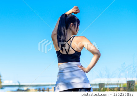 Back view of a cool woman exercising under the blue sky Walking Diet Exercise Exercise Back view of a cool woman exercising under the blue sky Walking Diet Exercise Exercise 125225882