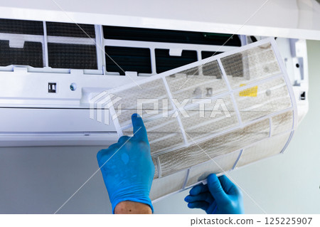 Essential Steps for Maintaining Air Conditioning: Cleaning a Filter for Optimal Cooling Performance and Energy Efficiency at Home or Office Environments 125225907