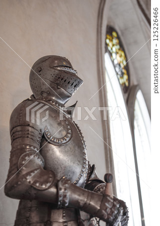 Side view of Medieval shiny armor and gothic pointed arches in white background Side view of Medieval shiny armor and gothic pointed arches in white background 125226466