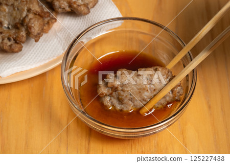 Deep-fried sardine meatballs served with chopsticks (stock photo) Deep-fried sardine meatballs served with chopsticks (stock photo) 125227488