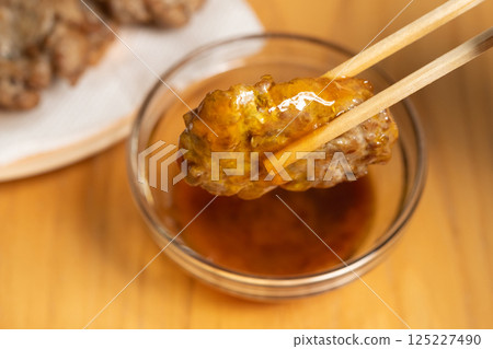 用筷子夾著的炸沙丁魚丸子（庫存照片） 125227490