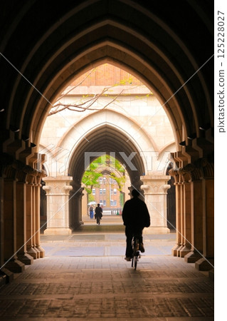 Silhouette of a cyclist passing through medieval Italian architectural landmarks Silhouette of a cyclist passing through medieval Italian architectural landmarks 125228027