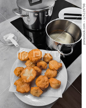 Freshly fried doughnuts, boortsog, boorsok cooling on plate in prague kitchen Freshly fried doughnuts, boortsog, boorsok cooling on plate in prague kitchen 125229798