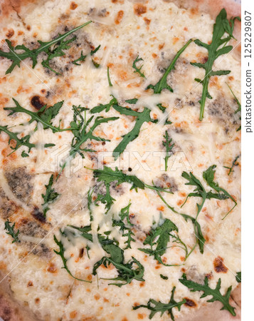 Delicious four cheese pizza with fresh arugula close up copy space Delicious four cheese pizza with fresh arugula close up copy space 125229807
