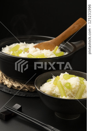 Rice cooked with butterbur in a clay pot on a black background Rice cooked with butterbur in a clay pot on a black background 125231996