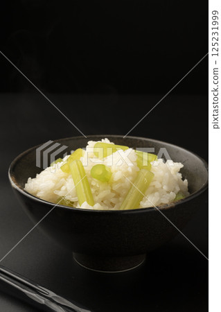 黑色背景中,用陶罐煮的白屈菜米 黑色背景中,用陶罐煮的白屈菜米 125231999