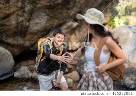 LGBT couple playfully reaching out to each other during their hiking adventure 125232091