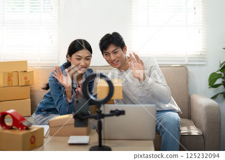 Connection and Communication. A couple engaging with their audience during a live video presentation. 125232094