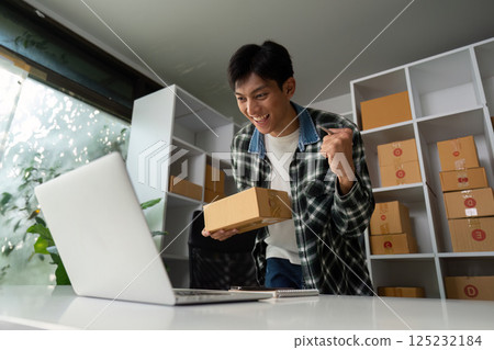 Entrepreneurship and Online Sales Achievement. A young man rejoices after receiving an order. Entrepreneurship and Online Sales Achievement. A young man rejoices after receiving an order. 125232184