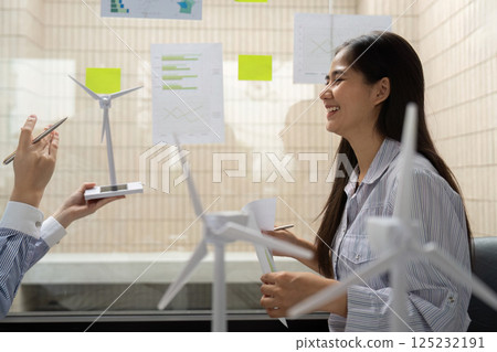 Engaging in ESG Strategies. A corporate professional shares insights on wind energy initiatives during a constructive meeting. 125232191