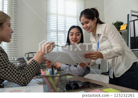 Collaborative team reviewing financial documents and tax strategies in a contemporary workspace. 125232261