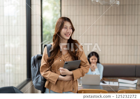 Student Life and Motivation. A student enters a bright study space, ready for productive learning and networking. 125232272