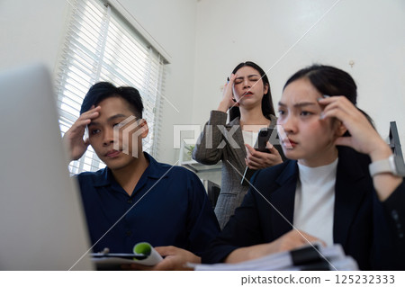Stressed team members discussing project challenges in a modern office setting. 125232333