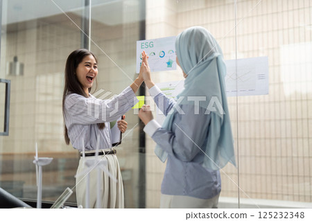 Joyful Collaboration for ESG Initiatives. Professionals celebrating progress in sustainability efforts through collaboration. 125232348