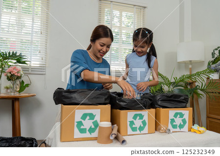 Recycling and Family Engagement. A mother and daughter sorting recyclable materials together. Recycling and Family Engagement. A mother and daughter sorting recyclable materials together. 125232349