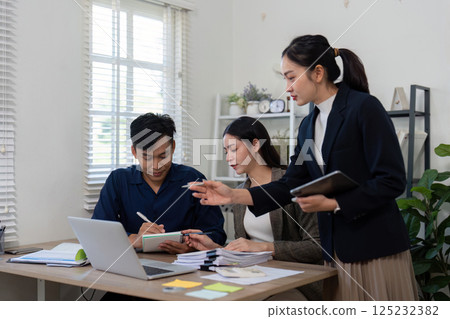 Strategic Planning and Discussion. A team collaborates on a project, analyzing important details and making decisions together. 125232382