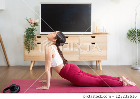 Yoga and Strength. A woman practicing the upward-facing dog pose for core strength. 125232610