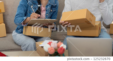 E-commerce Success and Planning. A couple working together to manage their online store and product packaging. 125232670