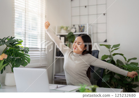 Break and Refresh. A woman enjoying a moment of relaxation during her work-from-home routine. 125232680