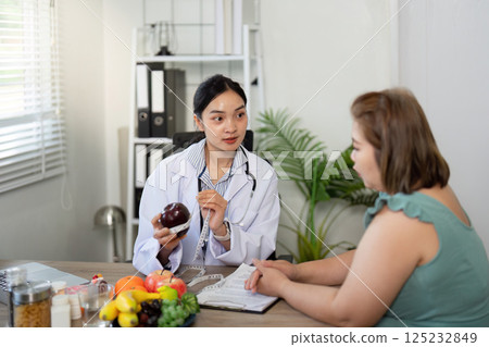 Dietary Counseling and Nutrition Guidance. A nutritionist explaining healthy eating principles while consulting with a client in a friendly atmosphere. 125232849