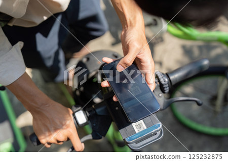 E-Bike Accessibility and Smart Solutions. A user engages with an e-bike app for sustainable transportation right from the bike. 125232875