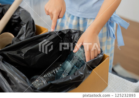 Recycling Awareness and Children. A child engages with waste materials, learning to recycle and promote sustainability in a playful manner. 125232893