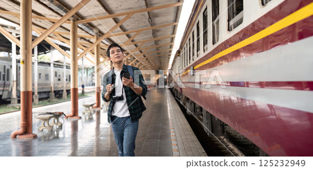 Travel and Rail Adventure. A traveler eagerly explores the train station, ready for an exciting journey. Travel and Rail Adventure. A traveler eagerly explores the train station, ready for an exciting journey. 125232949