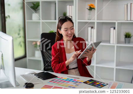 Creative Process and Digital Art. A graphic designer utilizing her tablet to explore new design concepts in a collaborative workspace. Creative Process and Digital Art. A graphic designer utilizing her tablet to explore new design concepts in a collaborative workspace. 125233001