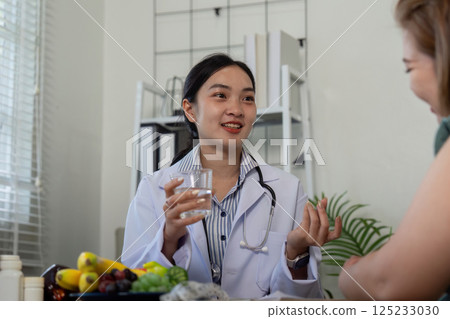 Nutrition and Consultation. A nutritionist discussing dietary options with a patient in a bright consultation room. 125233030