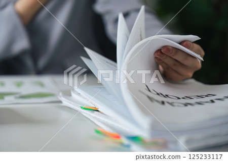 Documentation and Reporting. A professional handling multiple financial reports. Documentation and Reporting. A professional handling multiple financial reports. 125233117