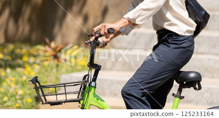 Active Transportation and Eco-Friendliness. The young cyclist prepares to ride, showcasing a green bicycle and displaying his water bottle, promoting sustainable commuting. Active Transportation and Eco-Friendliness. The young cyclist prepares to ride, showcasing a green bicycle and displaying his water bottle, promoting sustainable commuting. 125233164