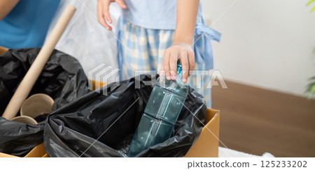 Plastic Recycling and Responsibility. A child participating actively in recycling efforts. 125233202