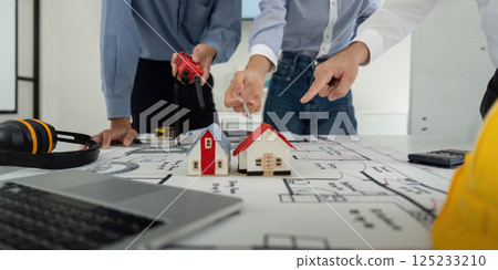 Construction Planning and Collaboration. Colleagues participating in a project meeting to design model houses. 125233210