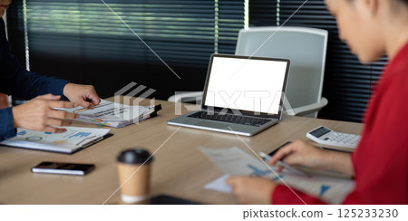 Collaborative Finance Review. Two professionals reviewing financial documents and strategies in a corporate environment. 125233230